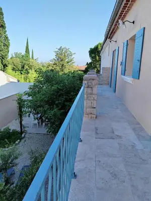 a walkway next to a building with a blue fence at Maison provençale rénovée in Pernes-les-Fontaines