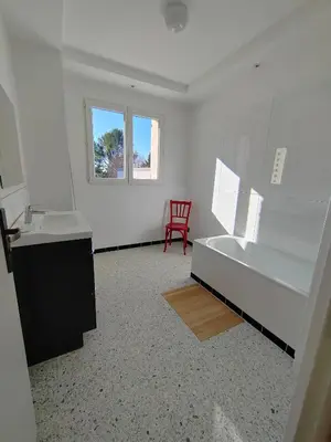 a white room with a bed and a red chair at Maison provençale rénovée in Pernes-les-Fontaines