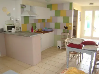 a kitchen with a counter and a table in it at vacances en provence cyprès in Mormoiron