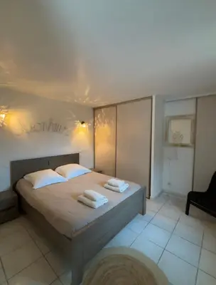 a bedroom with a bed with towels on it at Le Pavillon de Nina in Puget