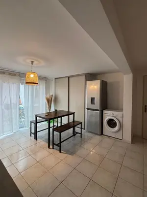 a kitchen with a table and a washing machine at Le Pavillon de Nina in Puget