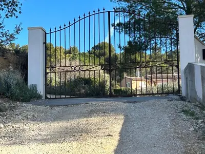 a gate to a house with a driveway at Le Pavillon de Nina in Puget