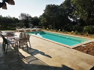 a swimming pool with chairs and a table next to it at Le Fiacre entre chênes et oliviers dans le Luberon in Cabrières-dʼAvignon