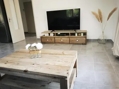 a living room with a tv and a coffee table at Le Fiacre entre chênes et oliviers dans le Luberon in Cabrières-dʼAvignon