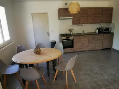 a kitchen with a wooden table and chairs in a room at Le Fiacre entre chênes et oliviers dans le Luberon in Cabrières-dʼAvignon