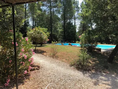 a garden with a swimming pool and some flowers at Le Clos des Cigales in Roussillon