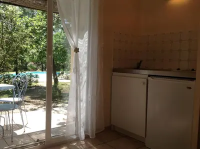 a kitchen with a sliding glass door to a yard at Le Clos des Cigales in Roussillon
