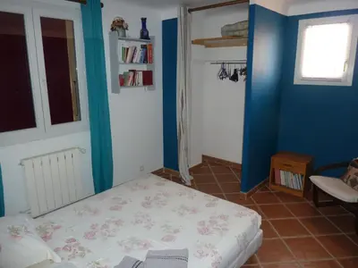 a small bedroom with a bed and a blue wall at Magnifique villa au calme avec piscine, sauna et jacuzzi in Pélissanne