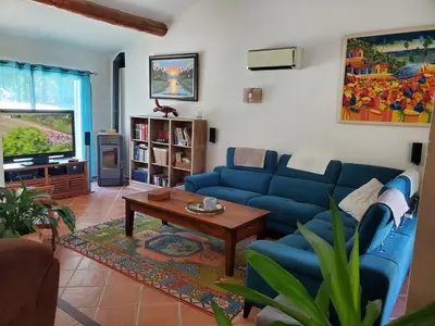 a living room with a blue couch and a table at Magnifique villa au calme avec piscine, sauna et jacuzzi in Pélissanne