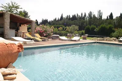a swimming pool with lounge chairs next to a house at Mirabelle en Provence in Eygalières