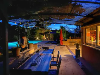 a patio with a swimming pool at night at Mas de Peyre in Le Beaucet