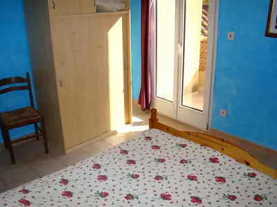 a bedroom with a bed and a window and a chair at vacances en provence olivier in Mormoiron