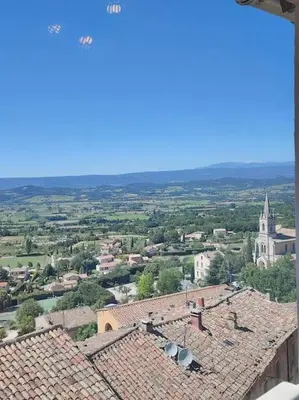 a view of a city with roofs and a church at BOHO 2 Vue Panoramique in Bonnieux