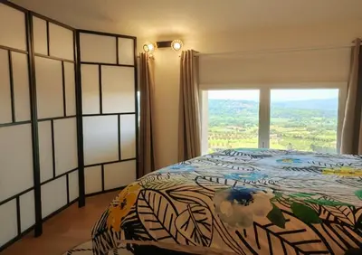 a bedroom with a bed and a large window at BOHO 2 Vue Panoramique in Bonnieux
