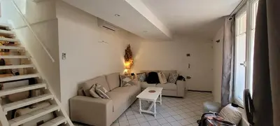 a living room with a couch and a table at Appartement duplex sur les toits d'Aix avec terrasse ensoleillée in Aix-en-Provence
