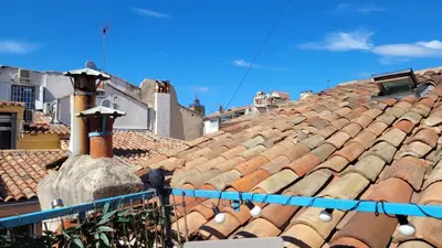 a view of roofs of buildings with a blue at Appartement duplex sur les toits d'Aix avec terrasse ensoleillée in Aix-en-Provence