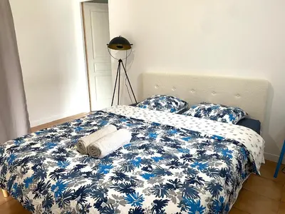 a bedroom with a bed with a blue and white comforter at Superbe annAix de villa - Maison Odonata in Aix-en-Provence