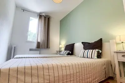 a bedroom with two beds and a window at Maison en Provence - Les Bastidons du Ventoux in Aubignan