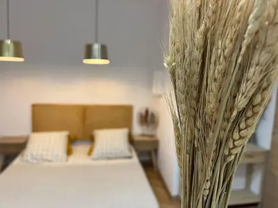 a bedroom with two beds and a vase filled with flowers at 4M Studio in Jouques