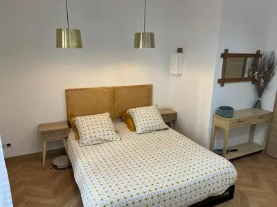 a bedroom with a bed and two tables and two lamps at 4M Studio in Jouques