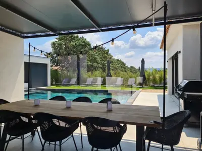 a patio with a table and chairs and a swimming pool at Villa de luxe en Provence Piscine Chauffée in Puget