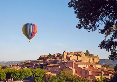 a hot air balloon flying over a village at BOHO 1 Vue Exceptionnelle in Bonnieux