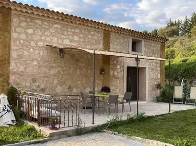 a patio with a table and chairs next to a building at Maison Campagne Aixoise in Éguilles