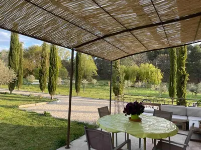 a table with a vase of flowers on a patio at Maison Campagne Aixoise in Éguilles