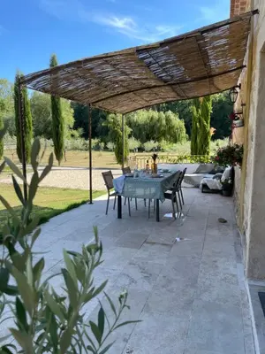 a patio with a table and chairs under a wooden pergola at Maison Campagne Aixoise in Éguilles