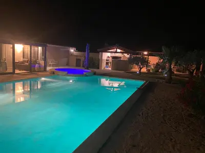 a swimming pool lit up at night at Petit paradis en Provence in Velleron
