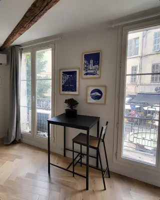 a table and chair in a room with a window at Appartement des Augustins in Aix-en-Provence