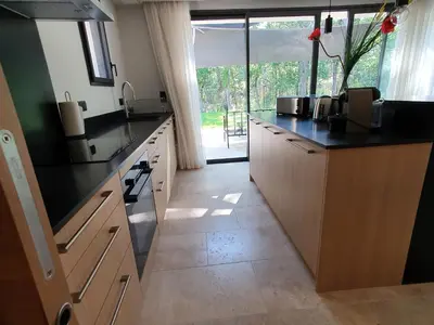 a kitchen with black counter tops and a large window at L'Instant Luberon in Gordes
