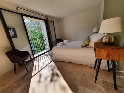 a bedroom with a bed and a table and a window at L'Instant Luberon in Gordes