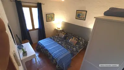 a bedroom with a blue bed with pillows on it at La Bastide de la Peyrolière avec piscine et tennis face au Luberon in Apt