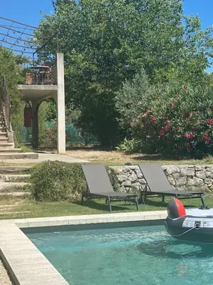 a pool with two benches and a boat in the water at Ar de Vie villa chaleureuse en Provence in Ventabren