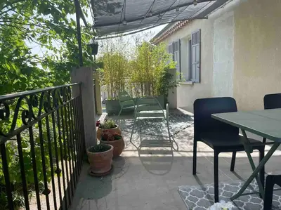 a patio with a table and chairs and a fence at Ar de Vie villa chaleureuse en Provence in Ventabren
