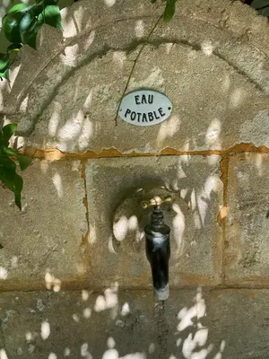 a brick wall with a faucet and a sticker on it at Eden - Mas de Rousseau in Eyragues