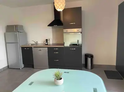 a kitchen with a table in the middle of it at Logement Le Puy Sainte Réparade in Le Puy-Sainte-Réparade
