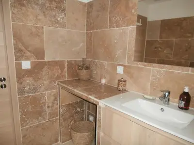 a bathroom with a sink and a tiled wall at gîte à Caromb ( Mt Ventoux ) in Caromb