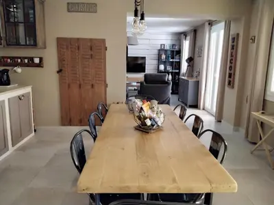 a dining room with a wooden table and chairs at MAS LAURIE in Cheval-Blanc