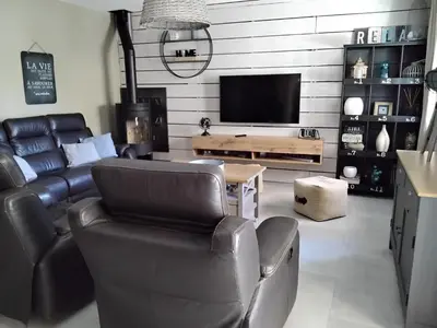 a living room with leather furniture and a tv at MAS LAURIE in Cheval-Blanc
