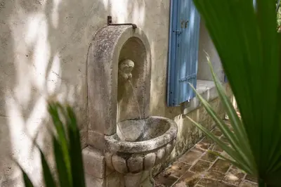a statue of a man in a toilet on the side of a building at Mas provençal 14 personnes - parking privé in Le Thor