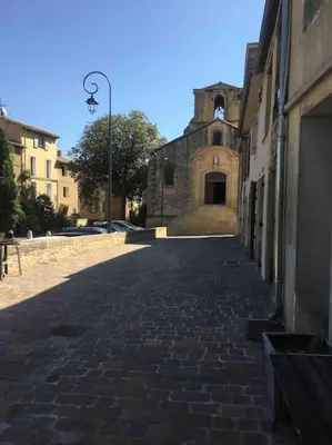 an empty street with a building and a street light at Magnifique studio indépendant 35m2 proche du lac et au coeur du village in Peyrolles-en-Provence