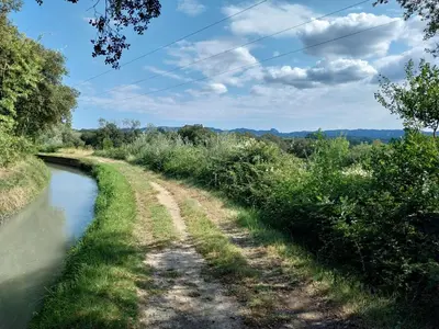 a dirt road next to a river at Cécile - Mas de Rousseau in Eyragues