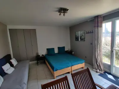 a bedroom with a bed and a couch at STUDIO DU CHARME PROVENCAL in Sénas