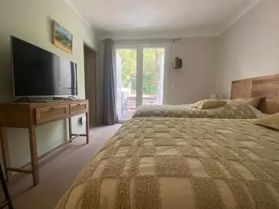 a bedroom with two beds and a flat screen tv at Le Repos du Keyrié in Saint-Marc-Jaumegarde