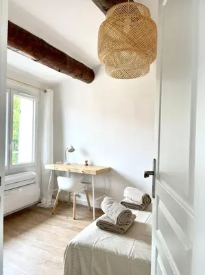 a room with a bed and a desk and a window at Ravissant appartement au cœur d’Aix in Aix-en-Provence