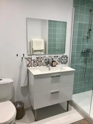 a bathroom with a sink and a shower with a mirror at Logement neuf, tout confort, au coeur du village in Saint-Didier
