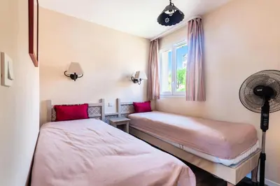 two beds in a room with a window at Les Coteaux de Pont Royal en Provence - maeva Home - Maison chaleureuse climatisée 4 pièces 6 personnes - Prestige - super Home MAE-2304 in Mallemort