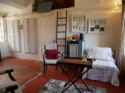 a living room with two chairs and a table at La maison de Muriel in Rustrel